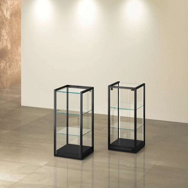 Vitrine colonne TM-45B noire en verre avec étagères en verre pour exposition de bijoux, montres et objets de valeur en boutique de luxe.