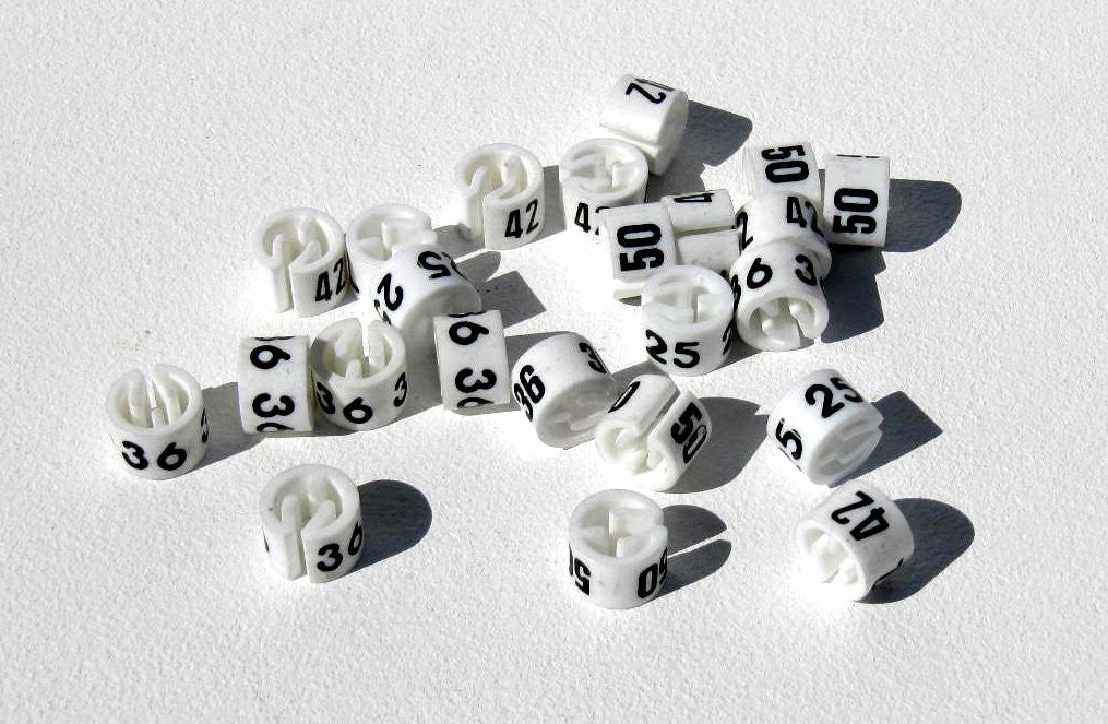 Bague blanche pour cintre avec tailles 24 à 62 imprimées en noir pour organisation en magasin
